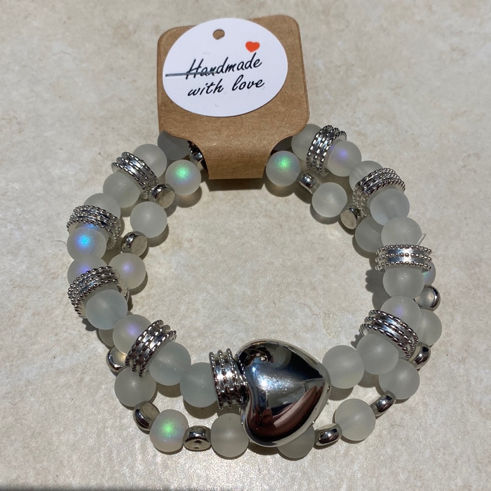 Two illuminating glass, beaded bracelets with spacers and a charm 6 1/2in